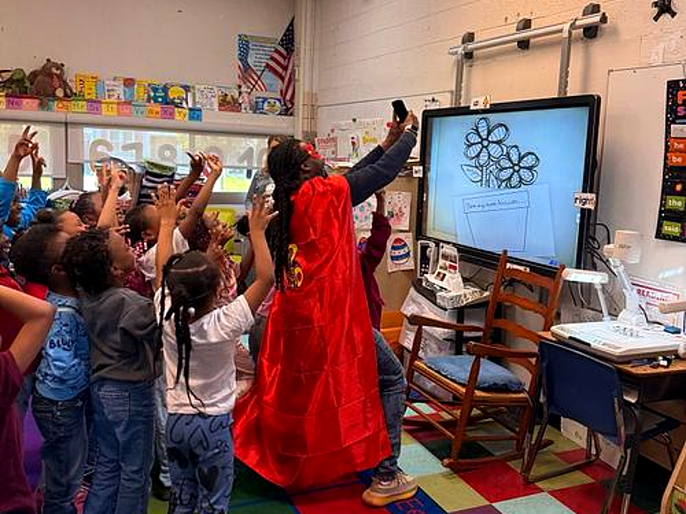 A Beacon classroom celebration with students raising their hands