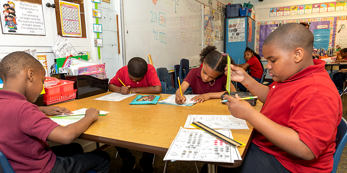 Beacon students working through a math lesson together at a classroom table