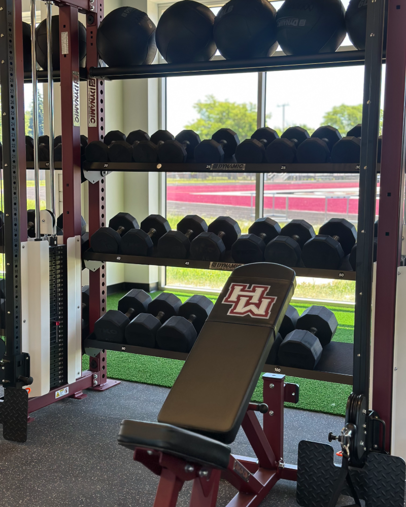 Dumbbell racks and an HW branded bench overlooking the track