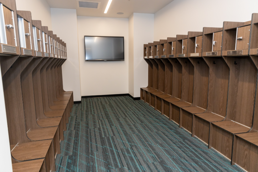 Locker room with wood lockers and a wall-mounted display