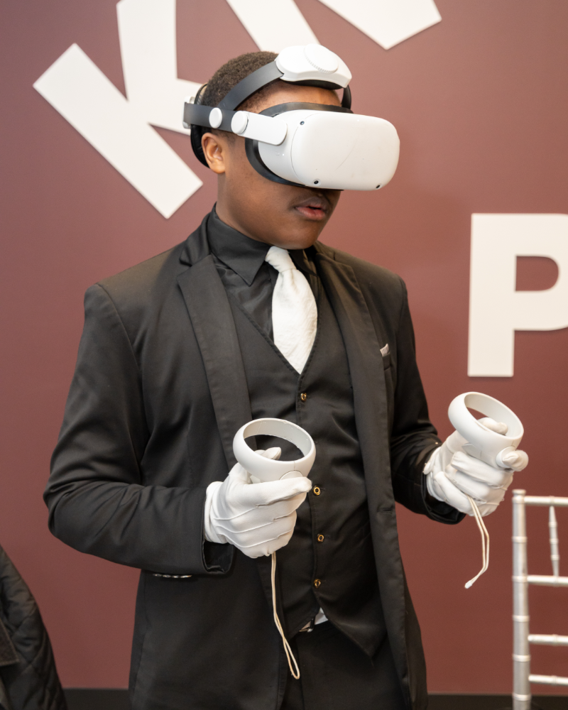 A Harper Woods student in a VR headset using hand controllers