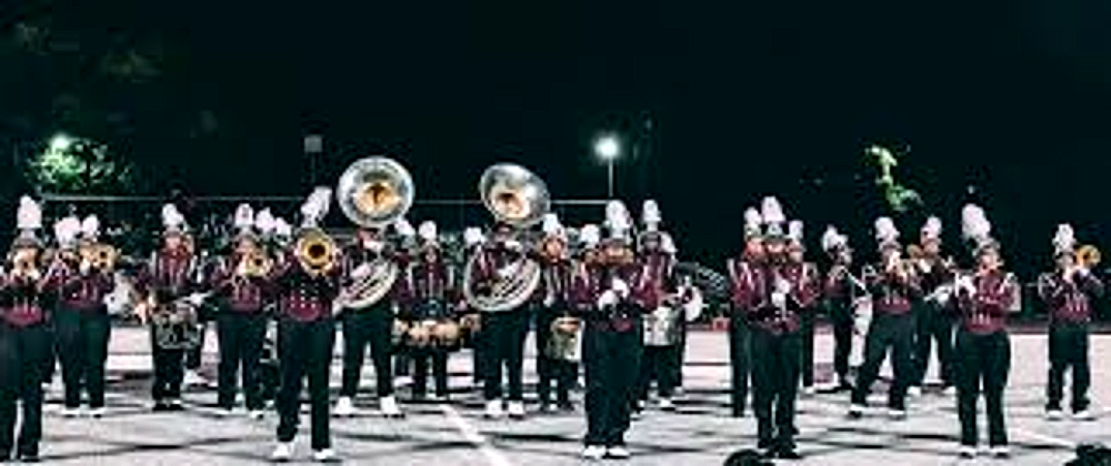The Harper Woods High School marching band performing under the lights
