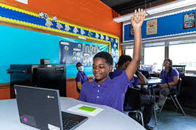 A Harper Woods Middle School student raising his hand in class