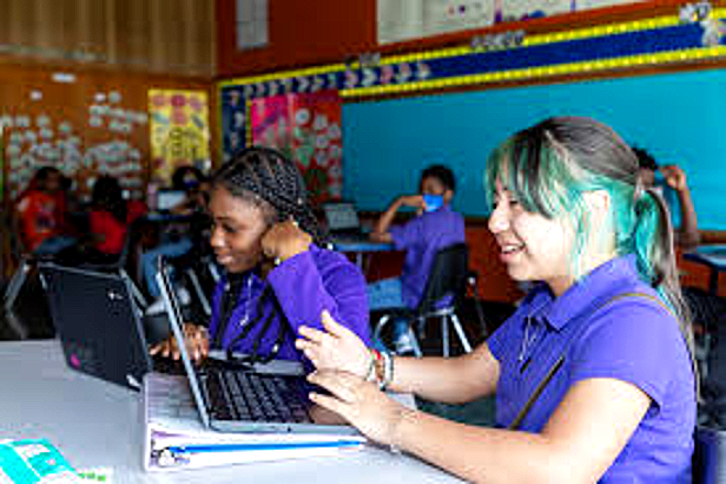 Two Harper Woods Middle School students collaborating on laptops