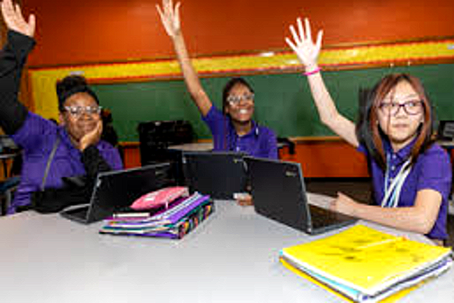 Three Harper Woods Middle School students raising their hands