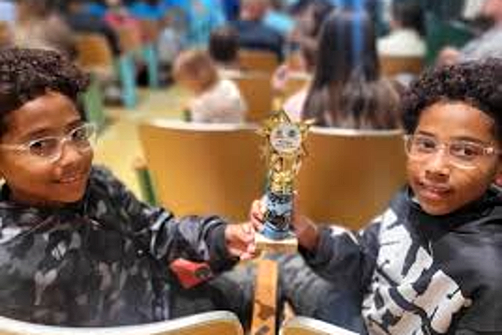 Two Tyrone students holding a competition trophy